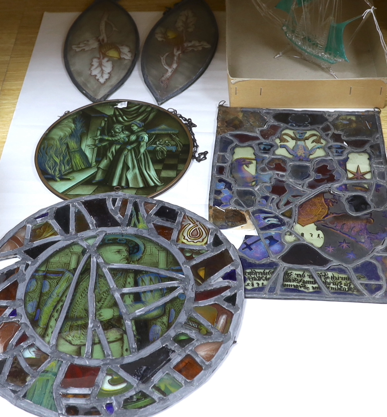 Two panels of early 19th century stained glass, largest 32cm, two tear drop panels, a later panel and a hand blown glass model of a galleon